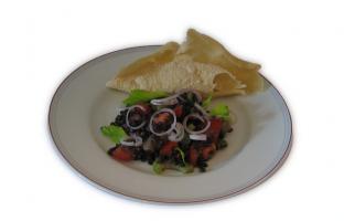 Linsensalat auf einem Teller angerichtet mit Pappadams