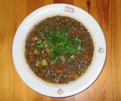 Ein Teller Linsensuppe mit Kartoffeln, garniert mit Petersilie